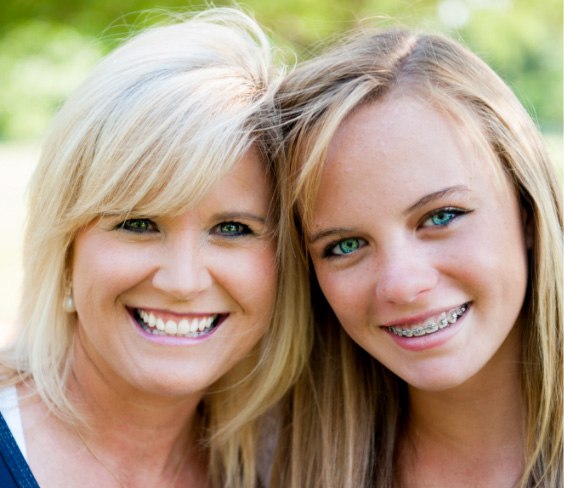 girl with braces smiling with her mother